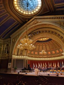 The Uppsala university orchestra playing a concert on stage in the ornate Universitetsaulan.